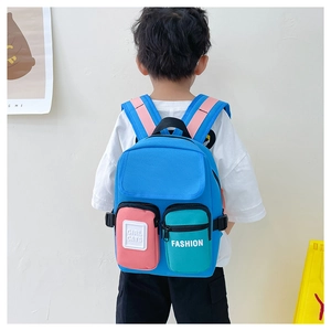 Rear view of a child wearing a colorful canvas backpack with blue, pink and green panels