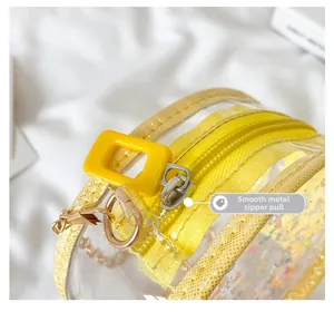 Close-up of a smooth metal zipper on a bright yellow translucent children's bag detail
