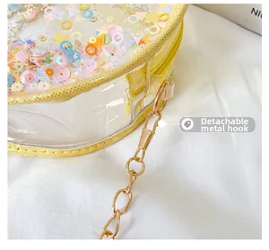 Detail of the detachable gold metal hook and chain on a stylish girl's round crossbody bag