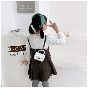 Girl carrying white quilted PVC jelly bag with pearl handle and golden chain strap