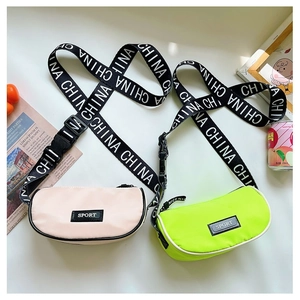 Gros plan des sacs bandoulière en nylon rose et vert avec sangles sportives pour enfants