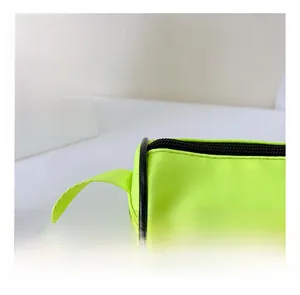 Détail macro du tissu en nylon vert fluo et de la fermeture éclair du sac pour enfants