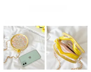 Detail of child's round crossbody bag showing double zipper pockets and glitter interior