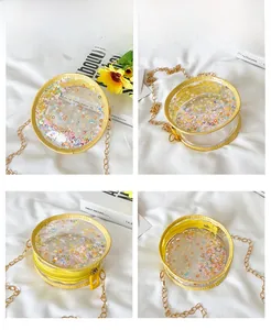 Detail view of round clear PVC crossbody bag with yellow trim and star glitter filling