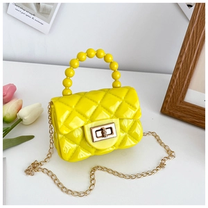 Close-up of a yellow quilted jelly bag with pearl handle and golden metal twist lock