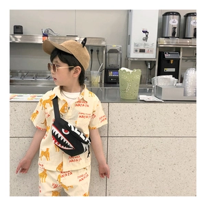 Close-up of kids black shark cross-body bag paired with Hakuna Matata leopard outfit