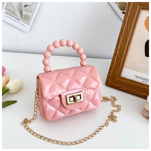 Detail of pink PVC jelly bag featuring quilted patterns and large pearl handle