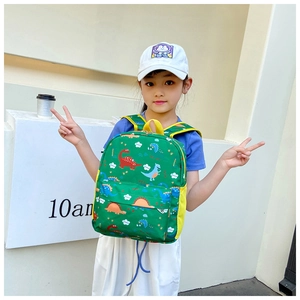 Detail of green kids dinosaur backpack with side mesh pocket and bright yellow handle