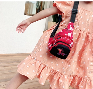 Gros plan d'un sac de poitrine rouge pour enfant en toile avec imprimé dinosaure