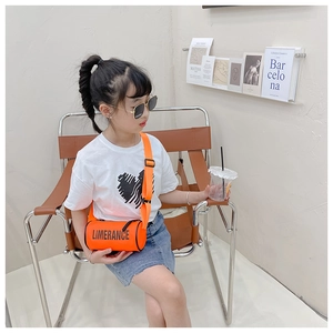 Détail d'un sac cylindrique orange pour enfant avec lettres, porté par une jeune fille