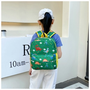 Detail of green kids dinosaur backpack with colorful prints and yellow mesh side pocket