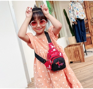 Détail du sac de poitrine rouge pour enfants avec broderie de dinosaure et sangle réglable
