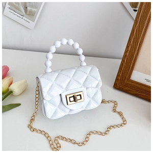 Detail of white quilted PVC mini bag with pearl handle and golden chain strap