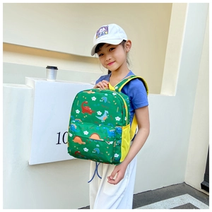 Detailed view of kids backpack with colorful cartoon dinosaur patterns and yellow mesh side pocket