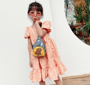 Détail du sac de poitrine enfant avec écusson dinosaure et toile à motif camouflage bleu