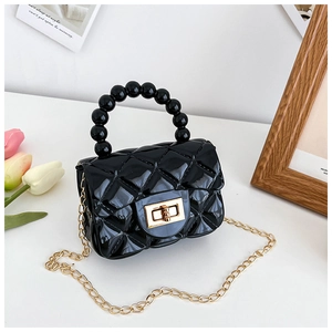 Detailed close-up of a black quilted PVC jelly mini handbag with beaded handle and gold chain
