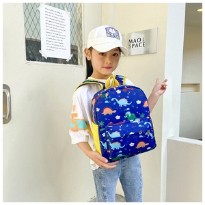 Close-up of children's dinosaur backpack showing colorful prints and yellow mesh pocket