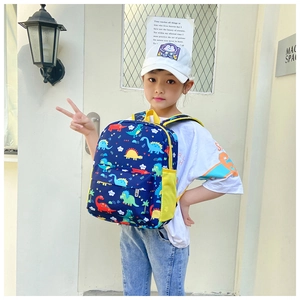 Side view of navy blue kids backpack with colorful cartoon dinosaurs and yellow side pockets