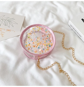 Detail of pink glitter round crossbody bag with colorful sequins and gold chain strap