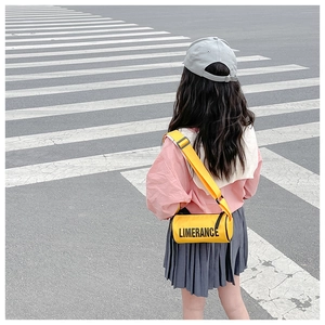 Détail d'un sac bandoulière cylindrique jaune vif avec texte Limerance pour enfants