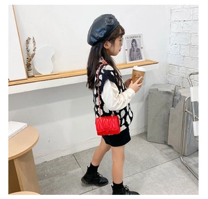 Detail of red quilted crossbody bag for girls with heart buckle and chain strap