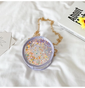 Detail of round transparent girl's bag with colorful glitter and golden chain strap