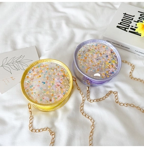 Detail view of round glitter chain bags with colorful sequins and stars in yellow and purple