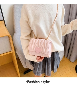 Close-up of pink quilted crossbody bag for girls with heart-shaped lock and gold chain