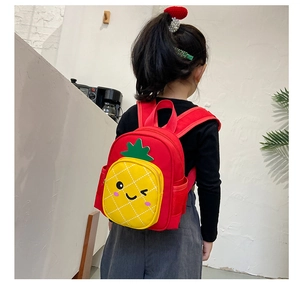 Detailed view of the red toddler backpack with a cute yellow pineapple pocket and green leaf