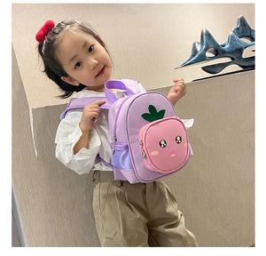 Toddler girl wearing cute purple backpack with a strawberry-shaped front pocket