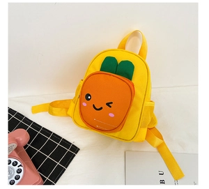 Detail of cute yellow kids backpack showing the orange carrot pocket and fun face design