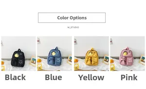 Detail of cute kid backpack with smiling face embroidery and a yellow duck plush toy