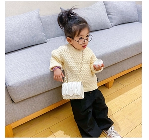 Toddler girl wearing white quilted crossbody bag with heart buckle and chain strap