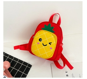 Detail of red canvas kids backpack featuring a cute yellow pineapple pocket with smiley face