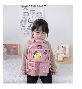 Detail of pink toddler backpack featuring a clear window with a cute yellow duck plush inside
