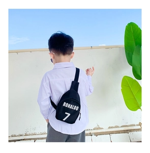 Detail of Ronaldo 7 black crossbody bag with adjustable strap worn by a young boy