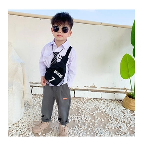 Detail of a kids black nylon crossbody chest bag with Ronaldo 7 print on a stylish outfit