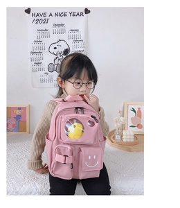 Detailed view of pink toddler backpack featuring transparent window with plush duck toy
