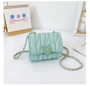 Detail of mint green quilted mini bag with heart clasp and gold-tone chain strap
