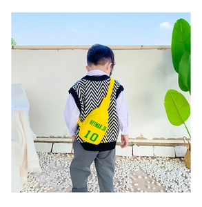 Detail of yellow canvas kids chest bag with green Neymar Jr 10 print and black zipper