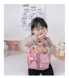 Detailed side view of pink kids backpack with duck pendant and adjustable buckles