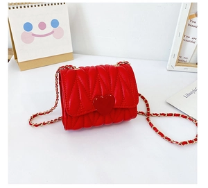 Detail showing red quilted heart crossbody bag with gold metal chain strap for girls