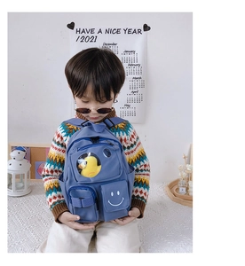 Blue kids backpack featuring clear front pocket with duck toy and smiley face print detail