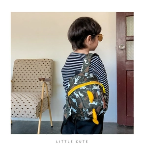 Close-up of kids dinosaur backpack featuring camouflage print and yellow scale details
