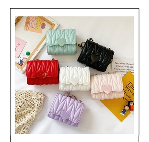 Detail of colorful mini quilted crossbody bags featuring heart-shaped clasps and chain straps