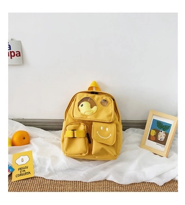 Detail of yellow toddler backpack featuring a clear window with a cute duck plush toy