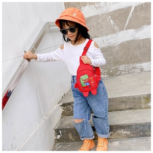 Détail du sac de poitrine dinosaure rouge en toile avec nageoires 3D pour enfants