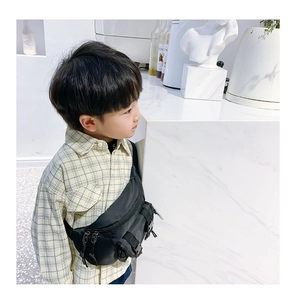 Close-up of black nylon kids chest bag with adjustable resin buckles and zip pockets