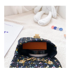 Vue détaillée de l'intérieur du mini sac bandoulière en tweed noir et sa capacité