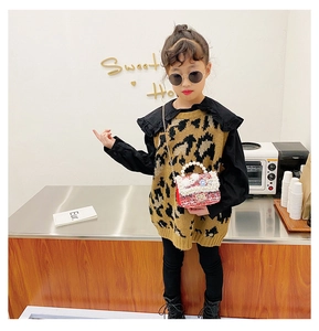 Detail of red tweed girls' handbag with pearl handle and knit leopard vest outfit